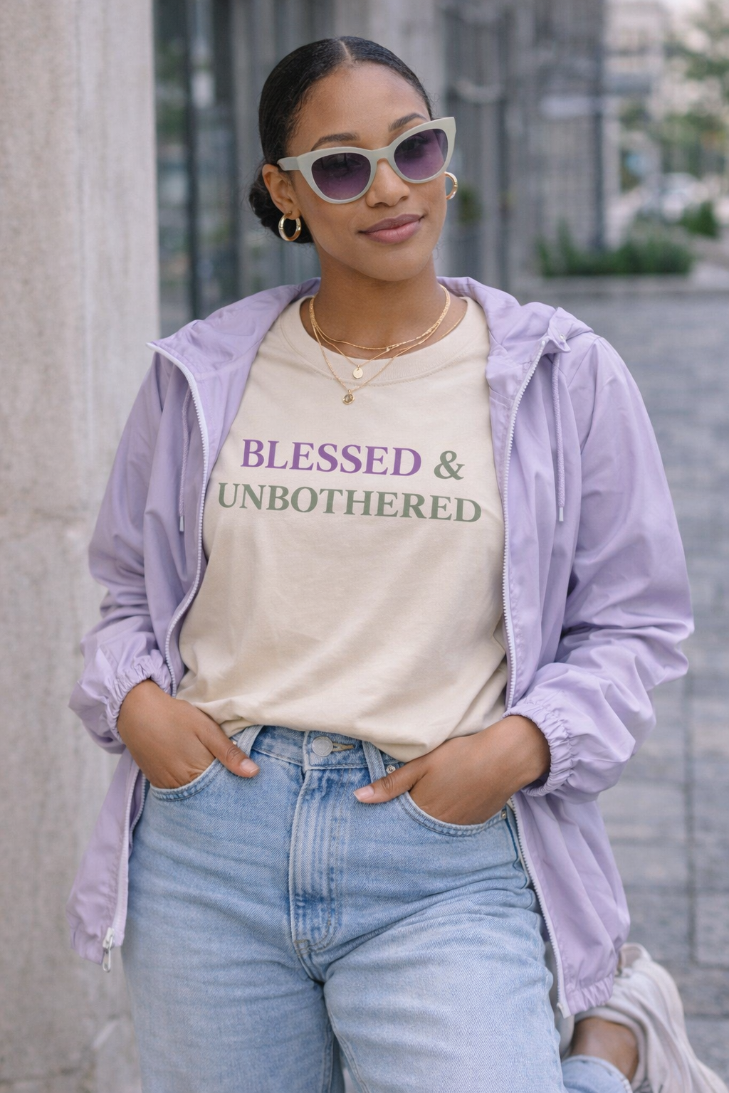 woman wearing blessed and unbothered t-shirt purple and sage minimalist faith based outfit with blazer and light wash denim