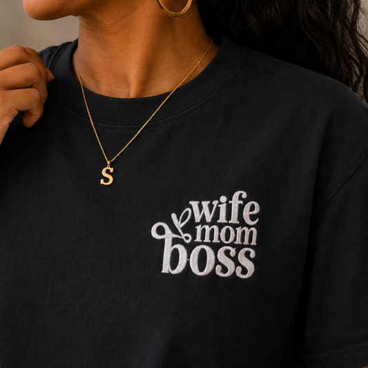 Close-up of white Wife Mom Boss embroidery on a black women’s boxy tee.