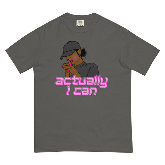 A women of color wearing a baseball cap in a thinking yet motivated posture above the words, Actually I can in pink on a pepper shirt on a white background.